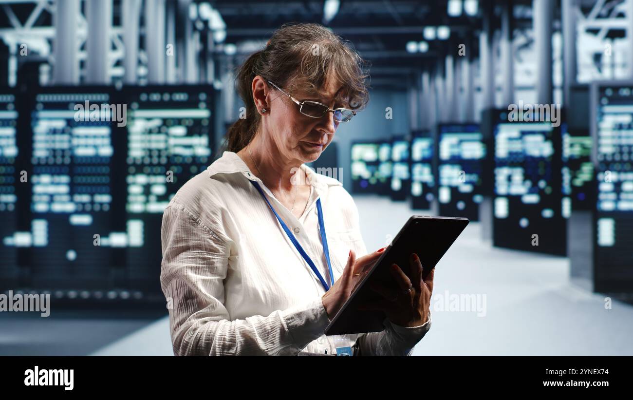 Senior programmer working in data center housing GPU dedicated server cabinets that can process artificial intelligence tasks with high efficiency, fixing defective machines used for machine learning Stock Photo