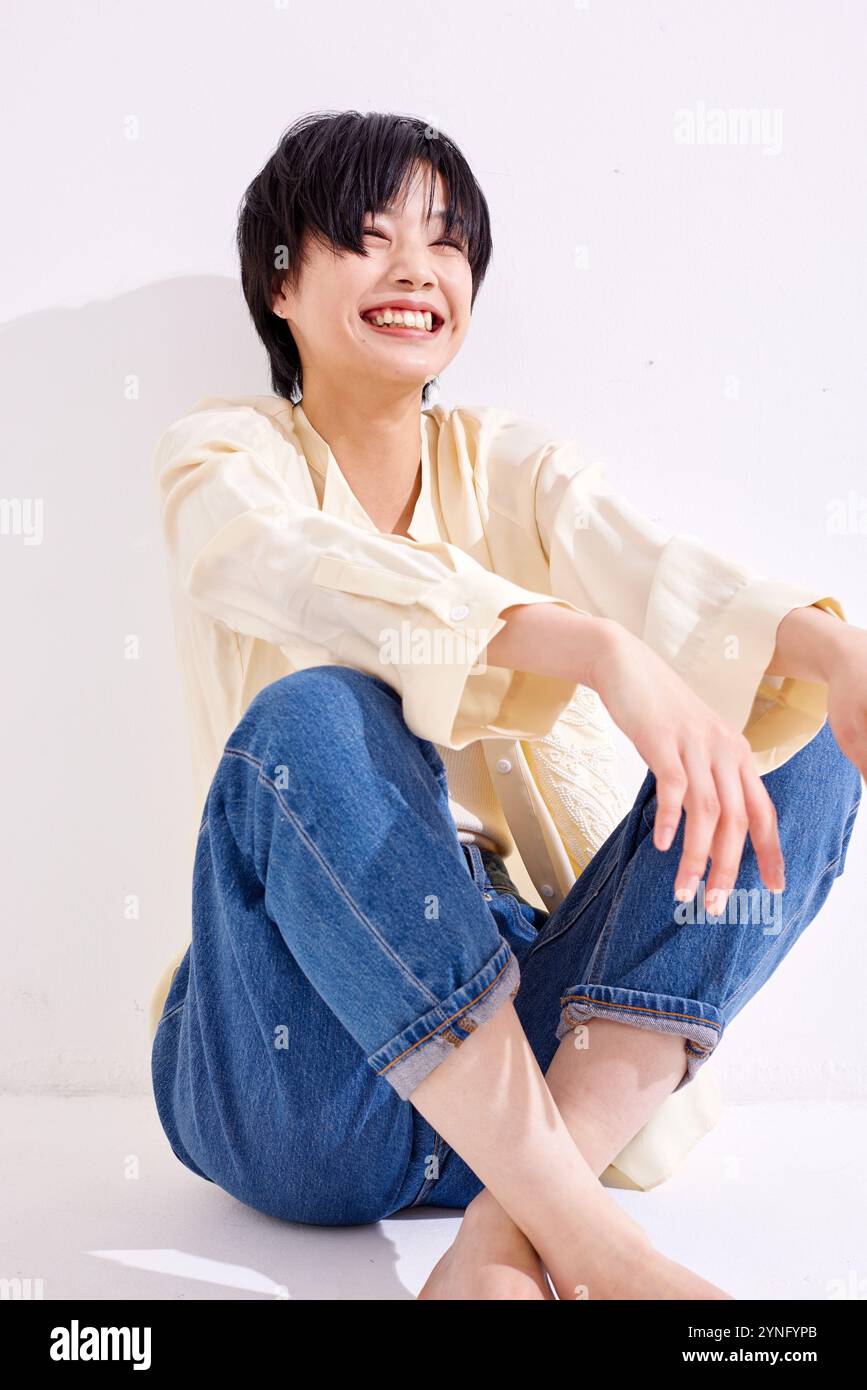 Japanese woman sitting on the floor smiling Stock Photo - Alamy