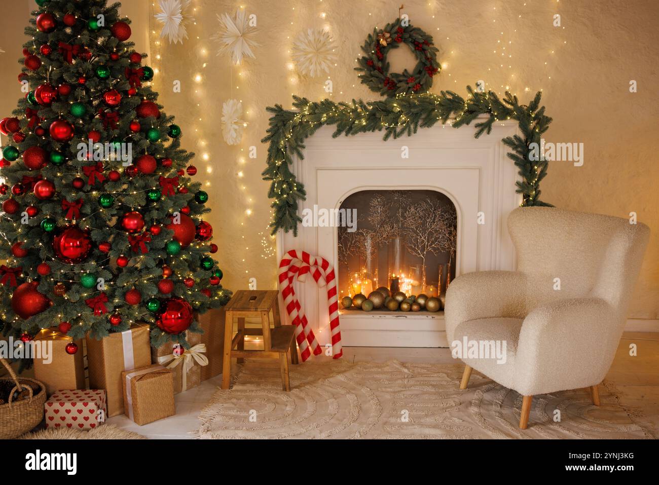 Evening Christmas interior of the living room decorated with garlands, a Christmas tree and a fireplace, a cozy New Year's room Stock Photo