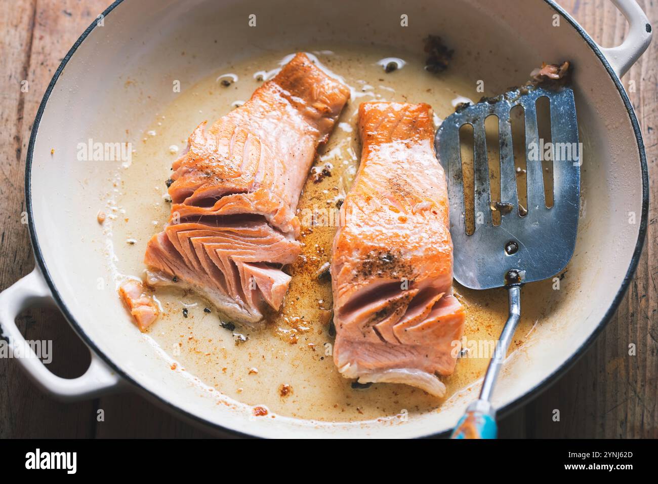 Salmon fried on oil on pan Stock Photo