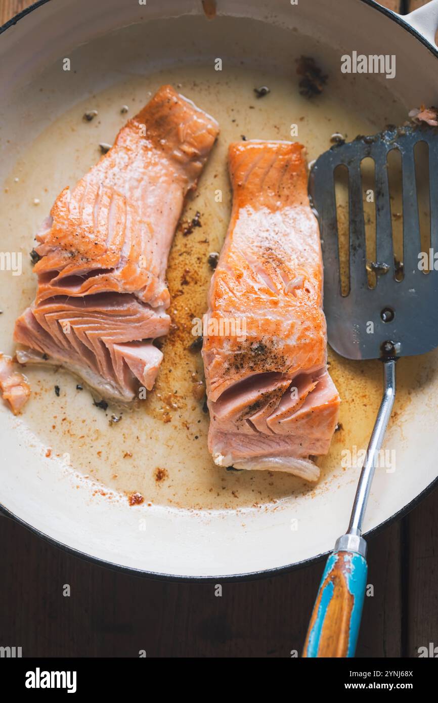 Salmon fried on oil on pan Stock Photo