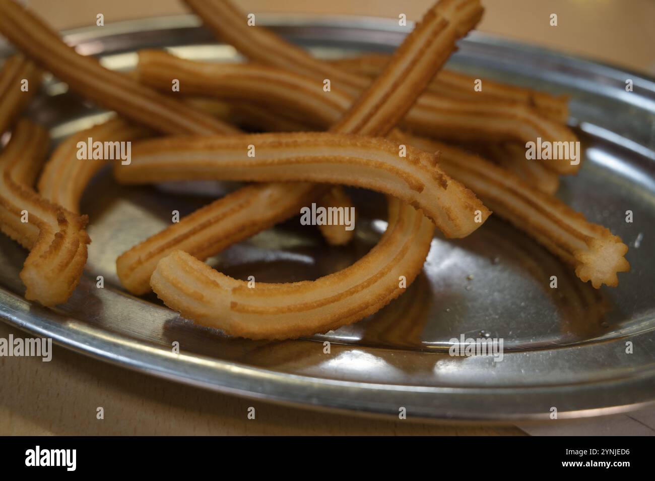 Golden crispy churros served on a silver plate Stock Photo - Alamy