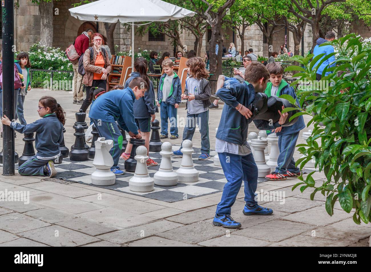 BARCELONA, SPAIN - MAY 10, 2017: Unidentified children play with giant chess in the courtyard of the Library of Catalan Literature. Stock Photo