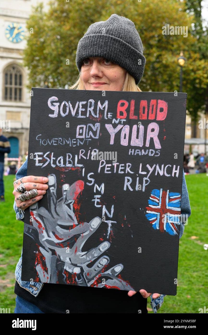 A woman at the 'Uniting the Kingdom' rally holding a sign in memory of Peter Lynch, who died in prison while serving his sentence for violent disorder Stock Photo