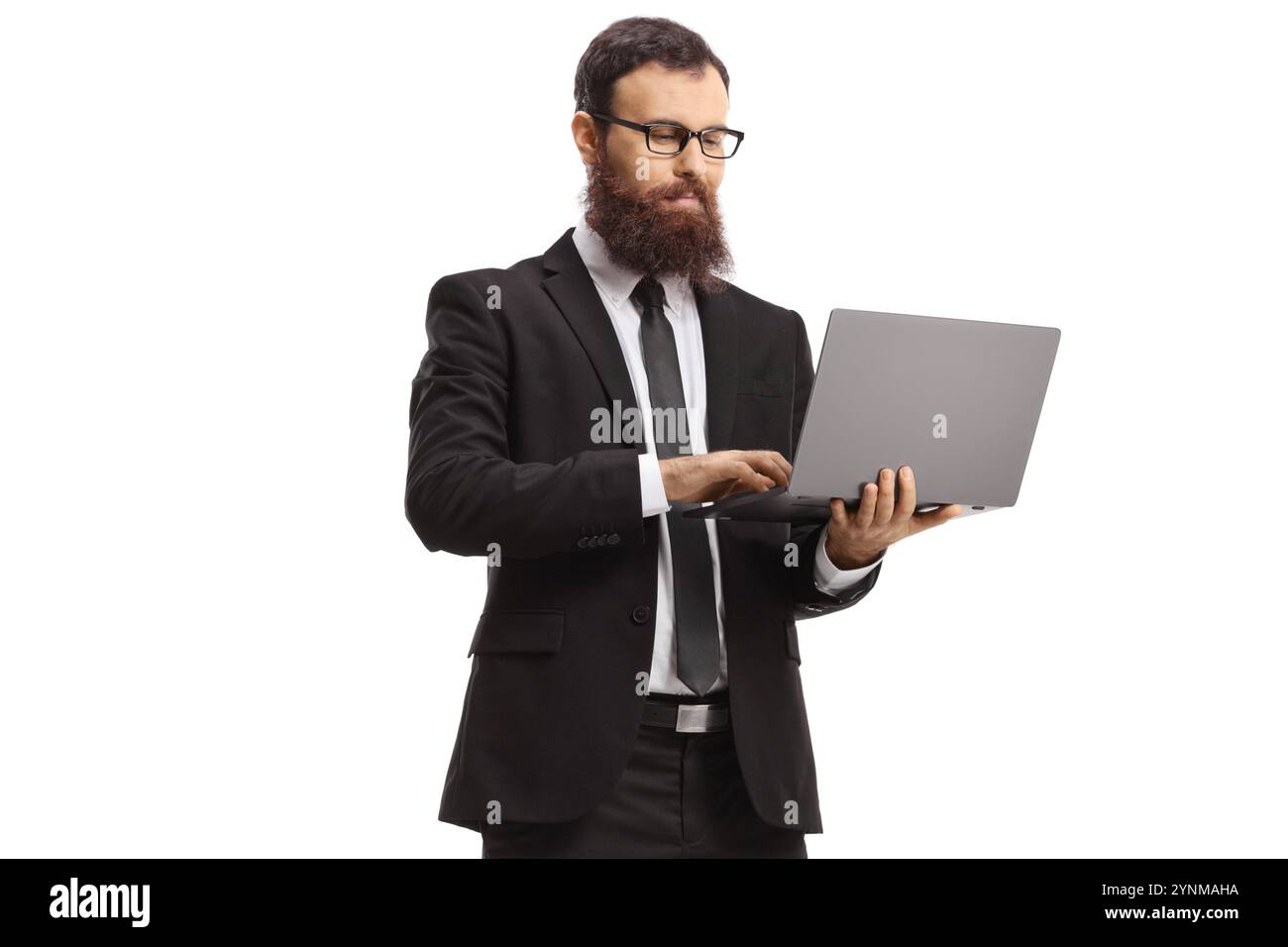 Bearded man in a suit standing and using a laptop computer isolated on ...