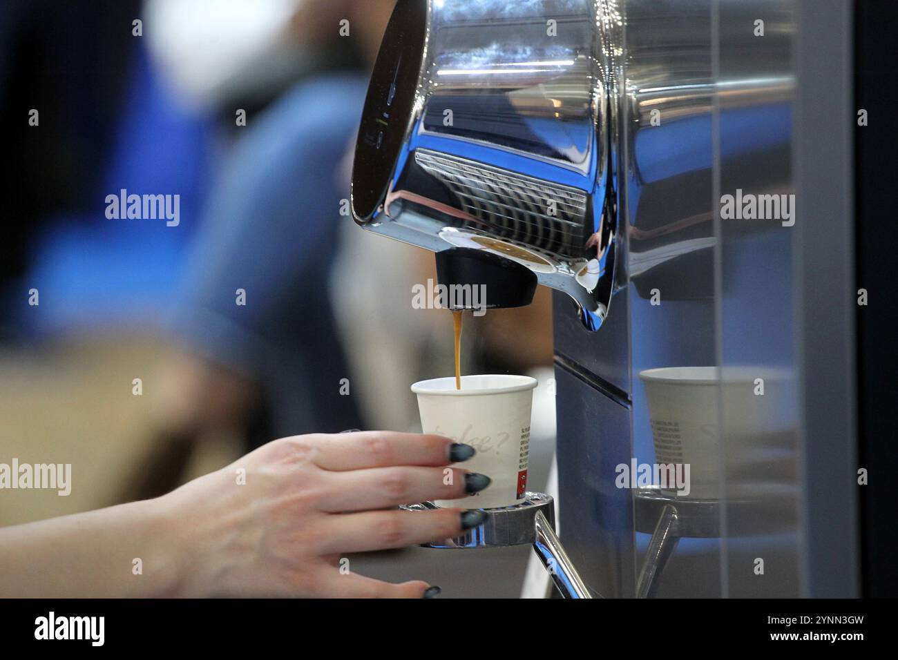 Fresh espresso dripping into a Nespresso-branded paper cup Stock Photo ...