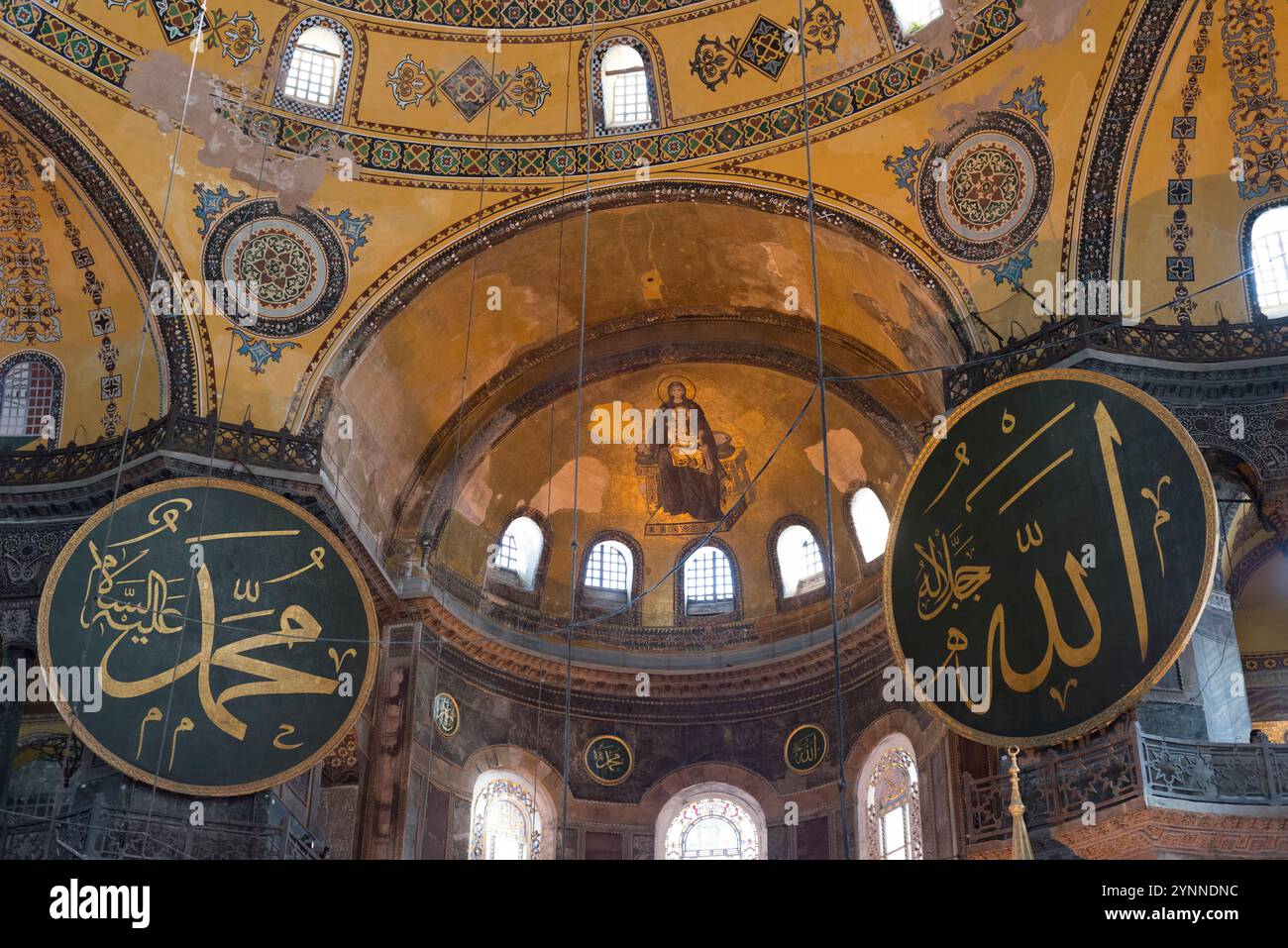Islamic calligraphy and Byzantine mosaics inside Hagia Sophia; a landmark mosque and a former church in Istanbul, Turkey. Stock Photo
