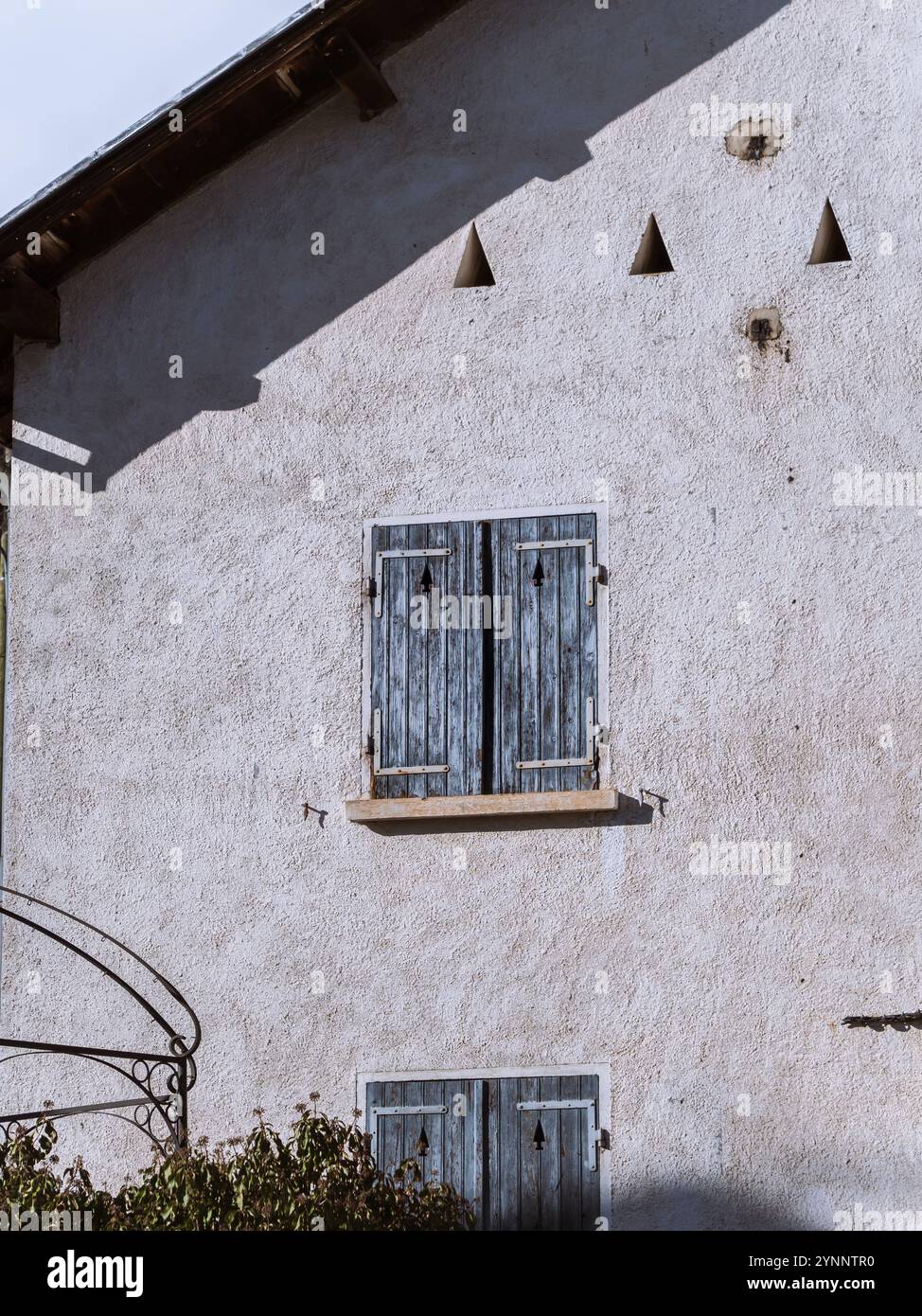 Image showcasing Rustic house with blue shutters and textured wall Stock Photo - Alamy