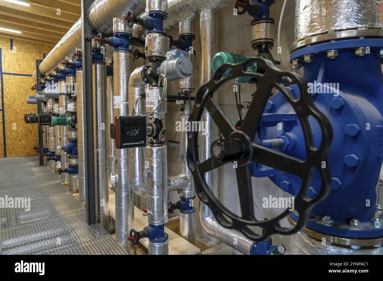 Pipelines, control elements of the heat storage tank of a biogas plant, 5000 cubic metres of hot water for buffering energy, for local heating supply Stock Photo