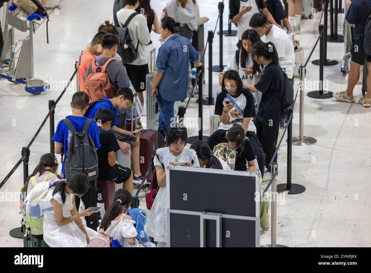 Travelers Waiting in Airport Queue for Check-In Stock Photo