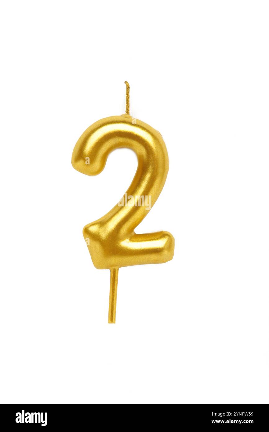 Gold candle in the form of number two isolated on white background. Top