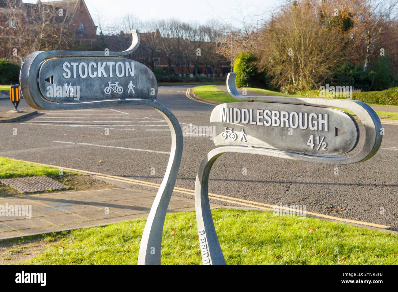 Metal directional signs for Stockton and Middlesbrough on a sunny day with pathways for pedestrians and cyclists Stock Photo