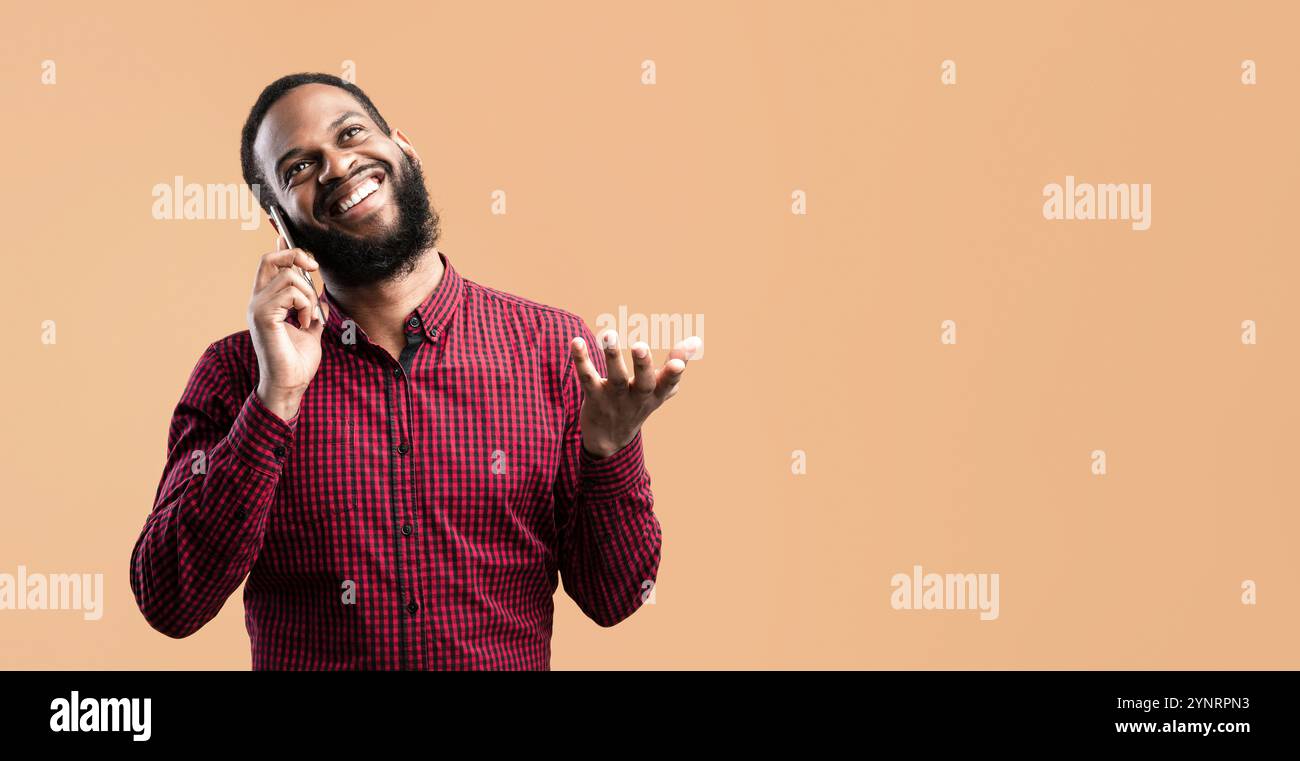 Smiling black guy talking on the phone and gesturing Stock Photo