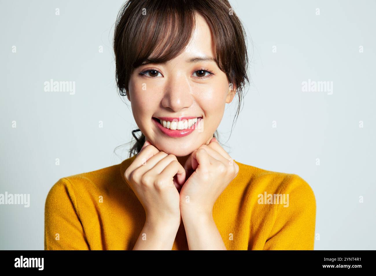 Portrait of smiling 20-something woman with hand on chin Stock Photo ...