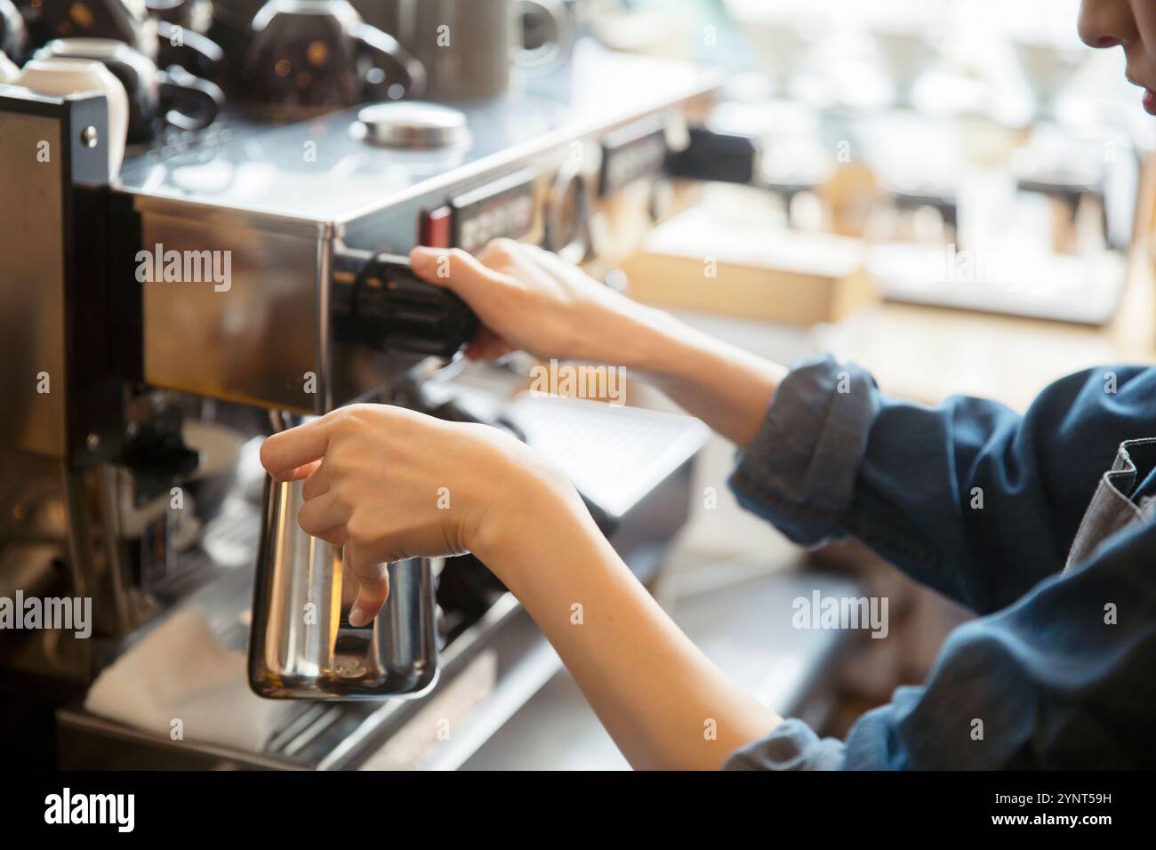 Woman making espresso at hand Stock Photo