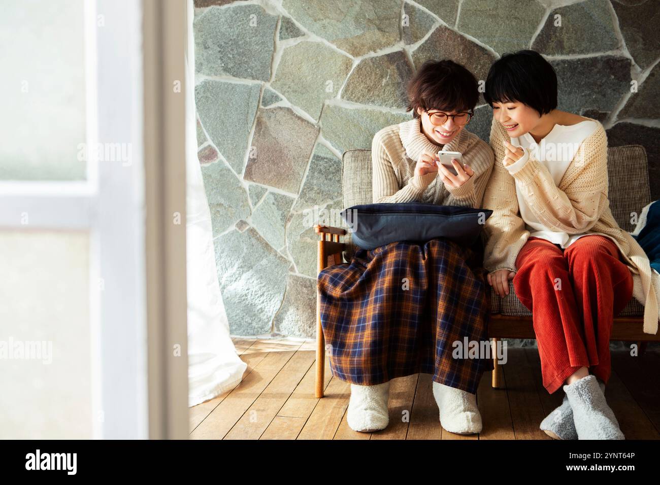 Two women in their 20s enjoying looking at their phones Stock Photo - Alamy