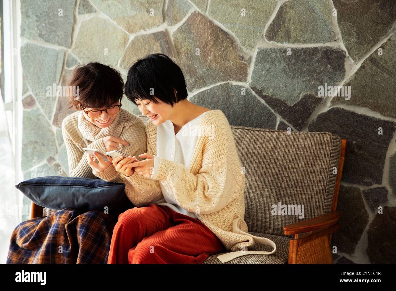 Two women in their 20s enjoying looking at their phones Stock Photo - Alamy