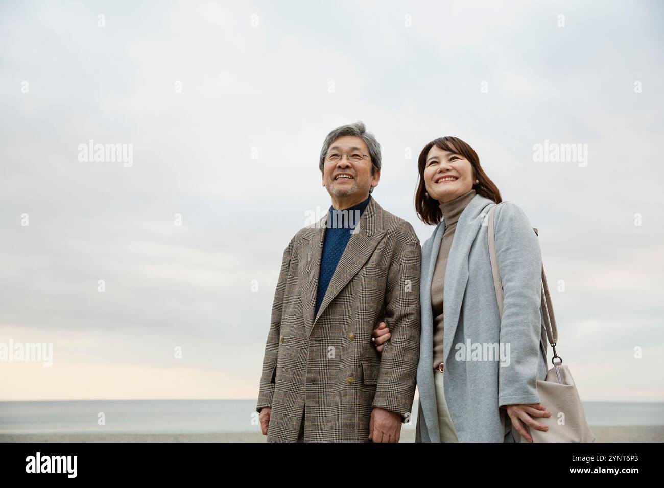 Smiling men and women standing under the evening sky Stock Photo