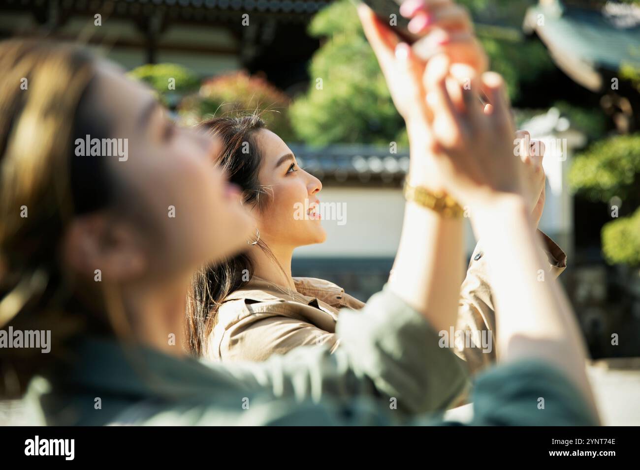 Two women in their 20s taking a photograph Stock Photo - Alamy