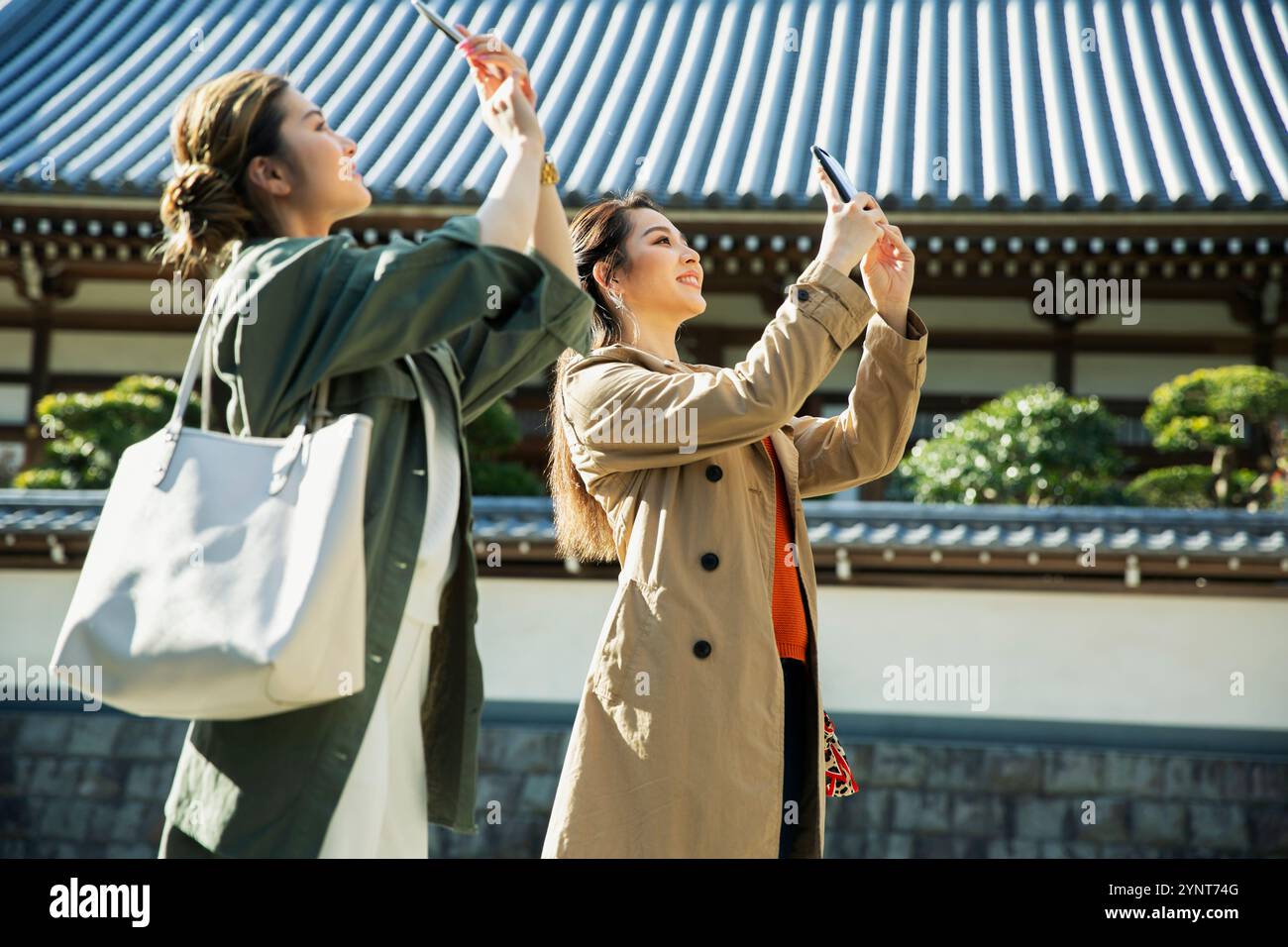 Two women in their 20s taking a photograph Stock Photo - Alamy