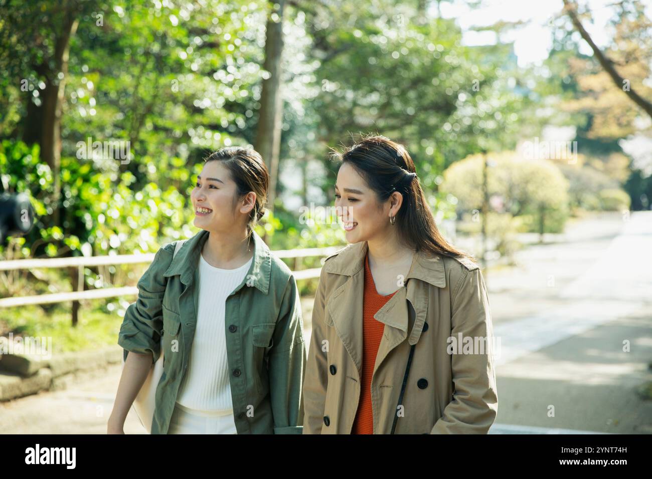 Two women in their 20s walking outdoors Stock Photo - Alamy