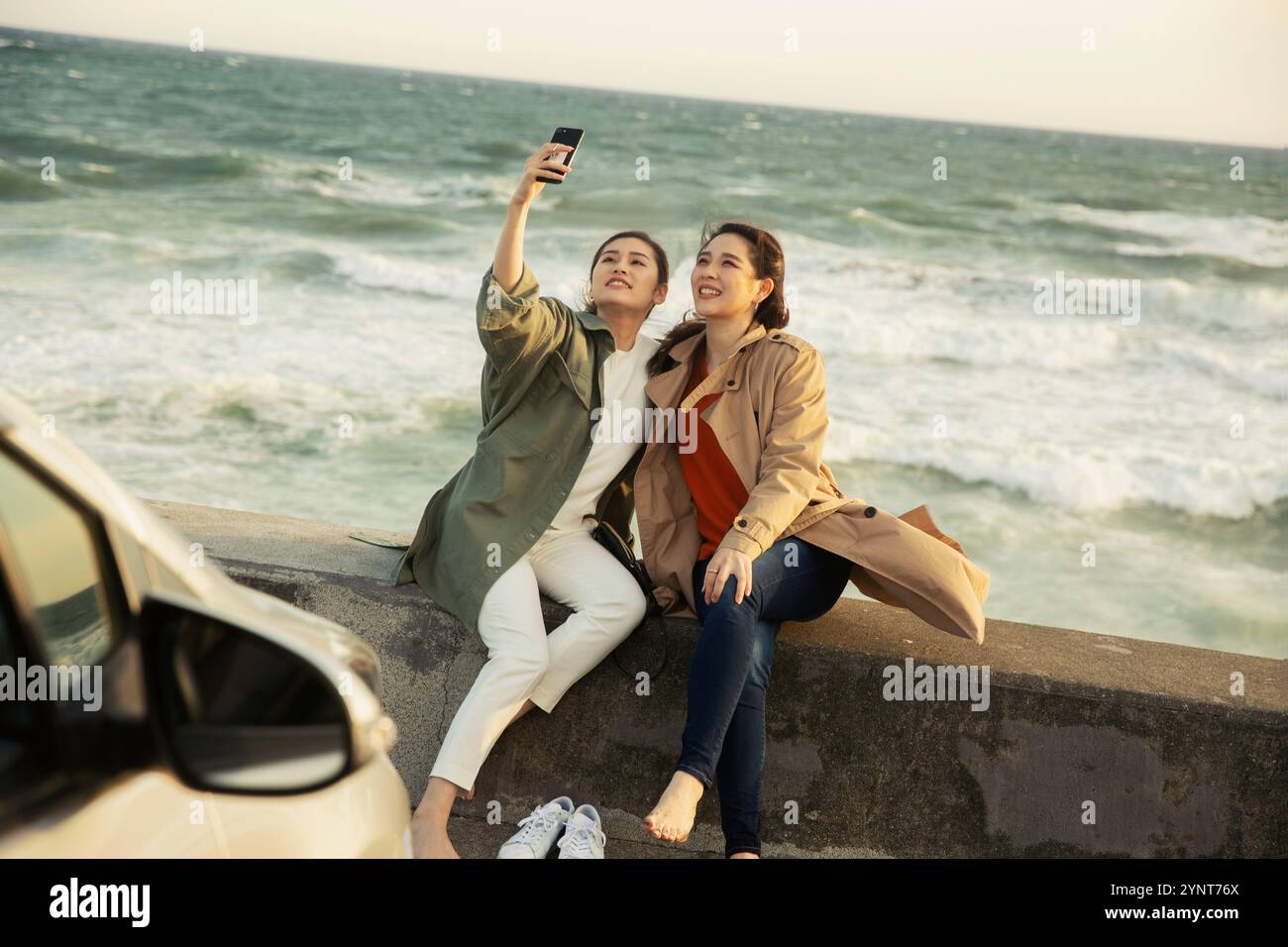 Two women in their 20s taking selfies in the surf Stock Photo - Alamy