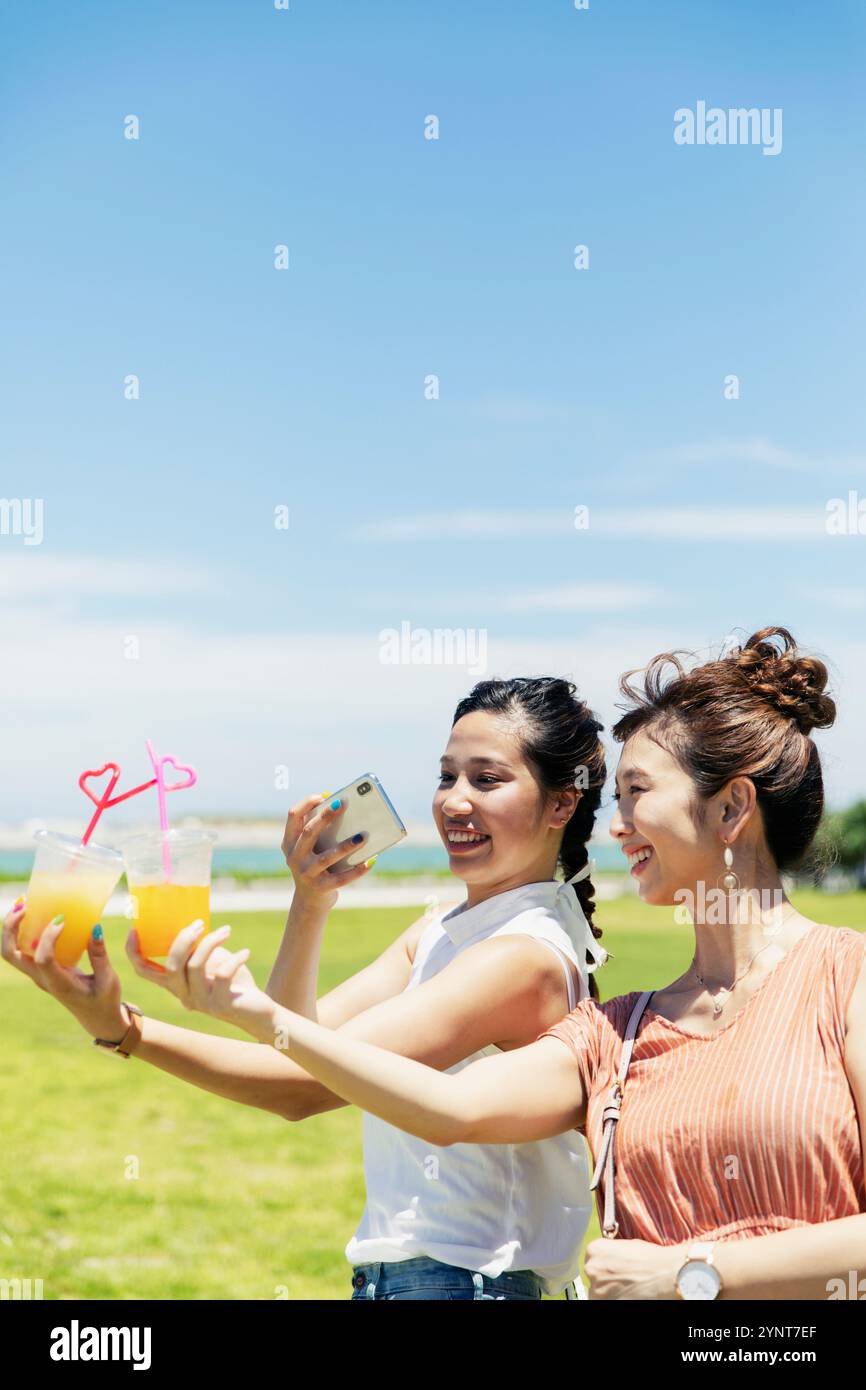 Two women in their 20s taking a picture of juice Stock Photo - Alamy