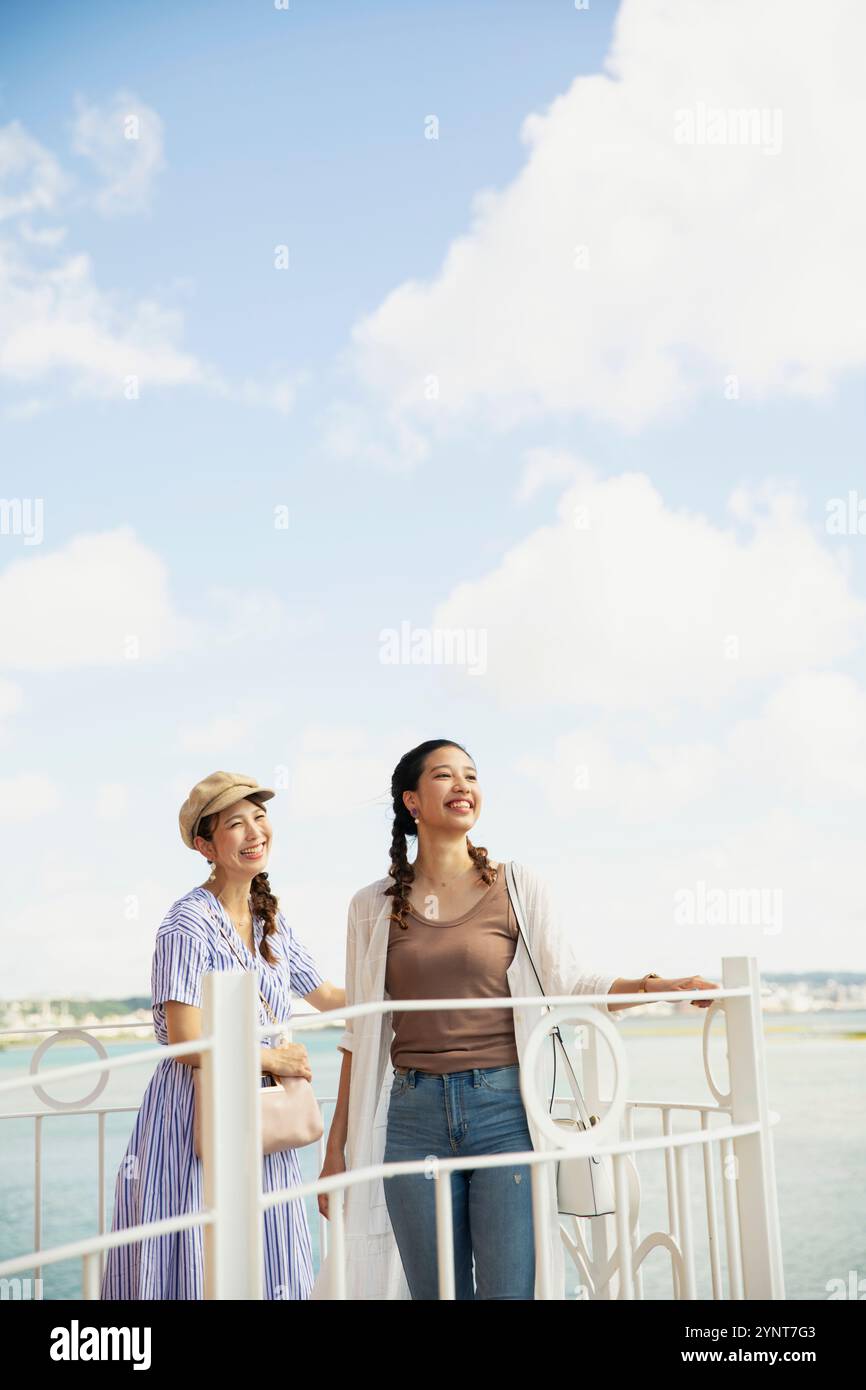 Two women in their 20s looking at the sea Stock Photo - Alamy