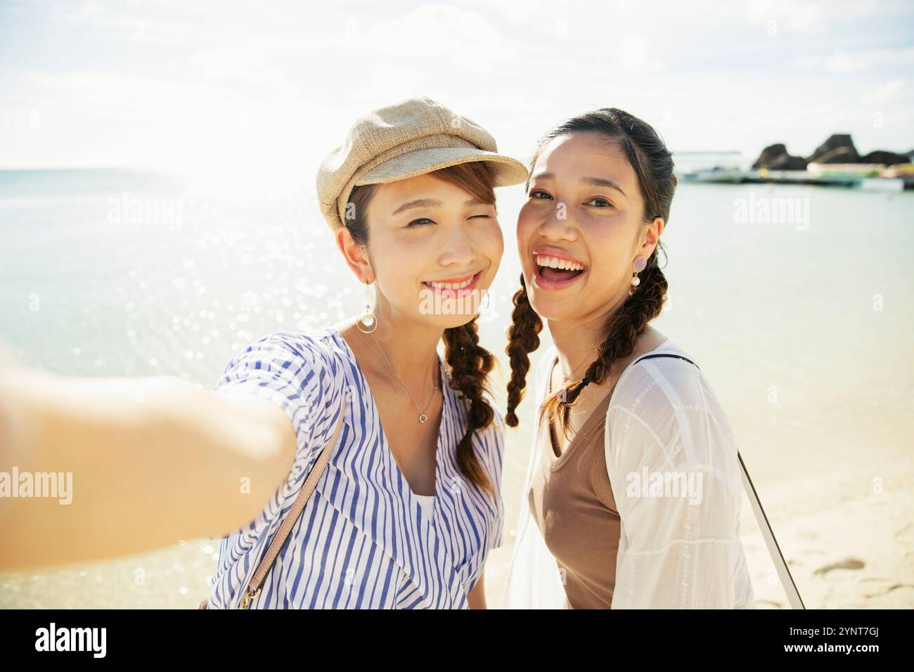 Two women in their 20s taking photos in the sea Stock Photo - Alamy