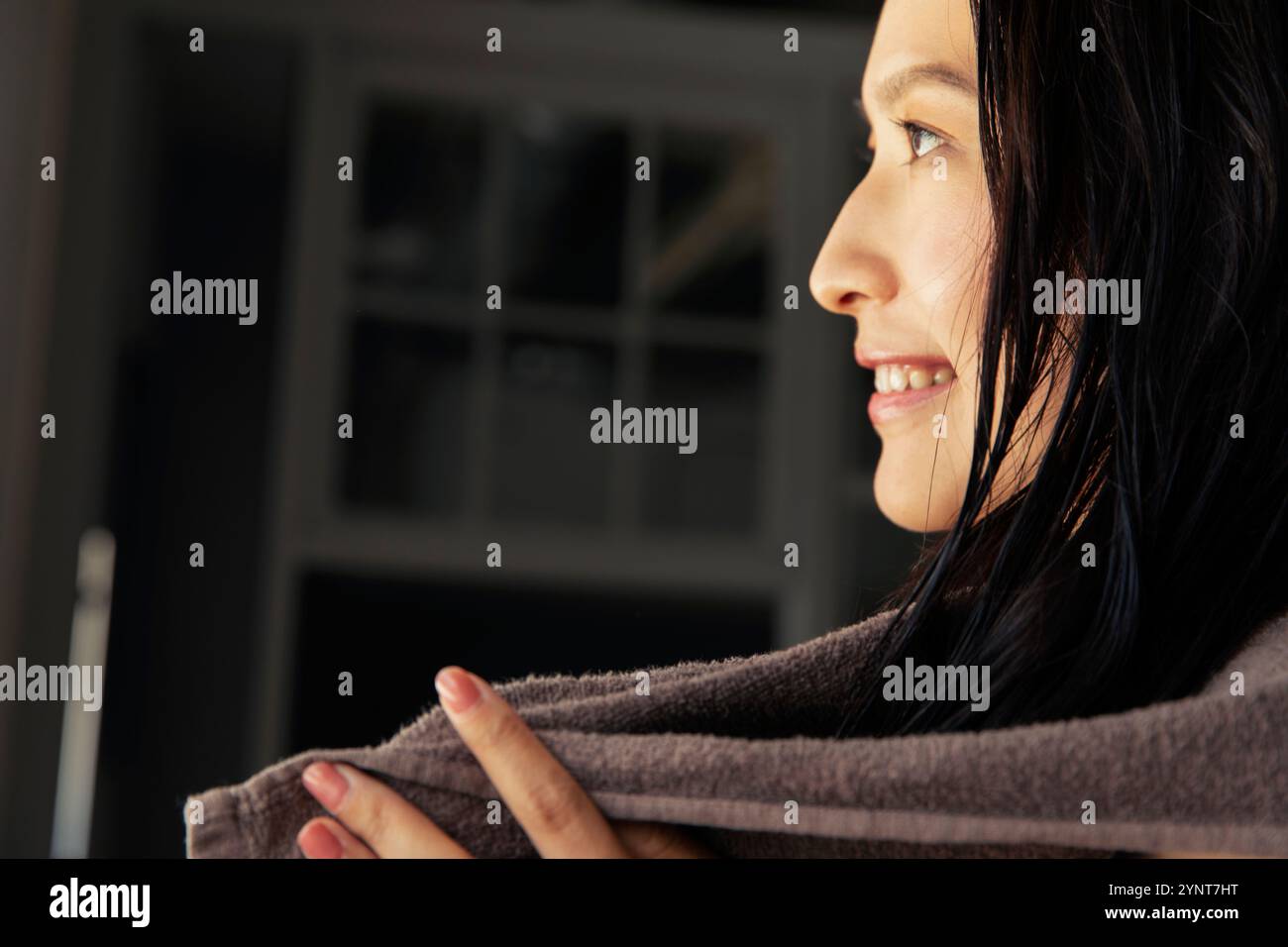 Smiling woman in her 20s looking out of the window after a bath Stock ...