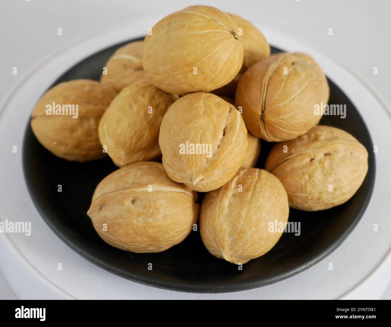 Fresh walnut on black plate with white background Stock Photo