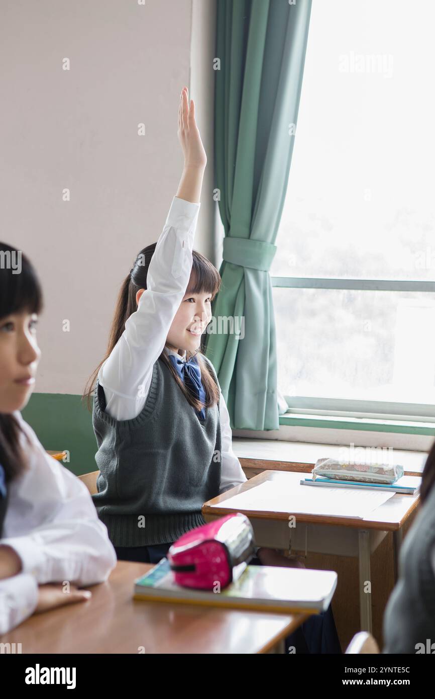Schoolgirl raising her hand Stock Photo - Alamy