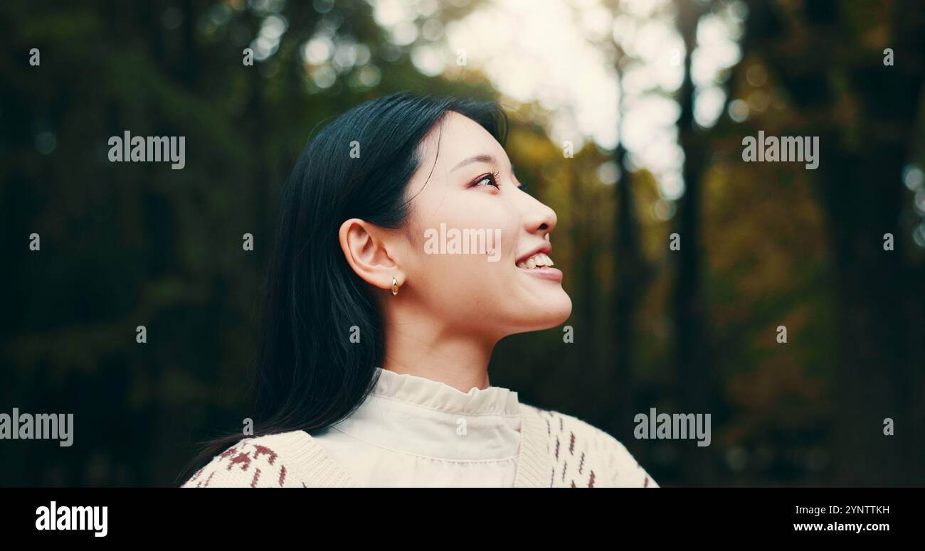 Japanese woman, thinking and outdoor with smile, confidence or pride in garden or park. Female person, happiness and biology student at university for Stock Photo
