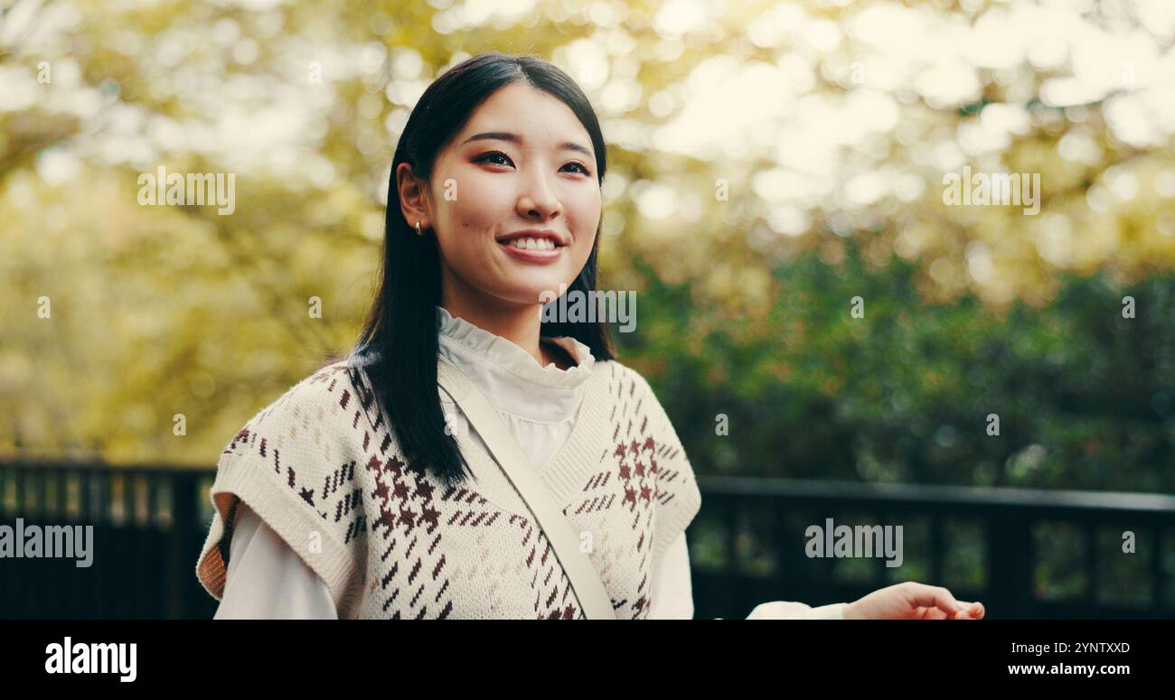 Japanese woman, thinking and outdoor with happiness confidence and pride in garden or park. Female person, smile and biology student at university for Stock Photo