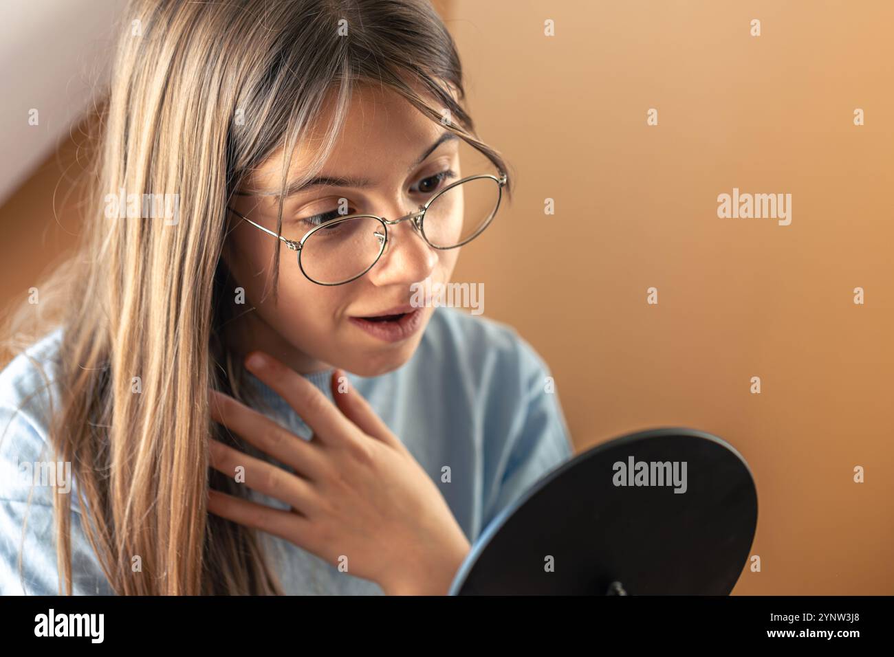 Morning Routine Glasses A beautiful girl in glasses looks at herself in the mirror.Morning ...