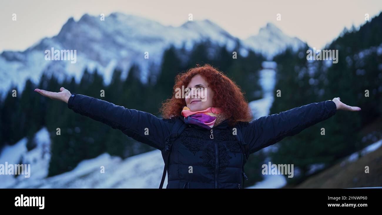 Curly hair redhead woman posing for a holiday shot with the Swiss Alps ...