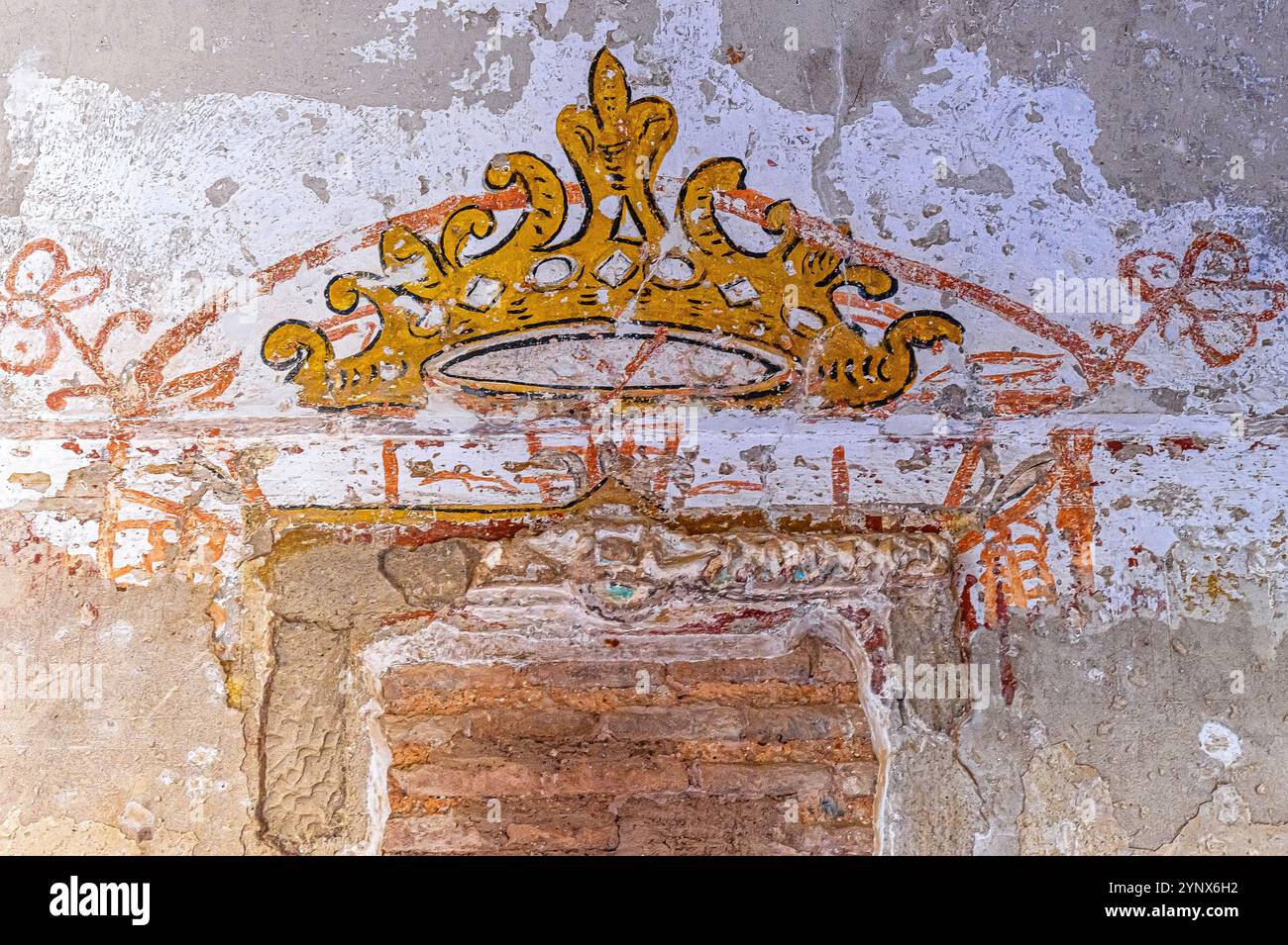 Granada, Spain - July 17, 2024: Ancient decorative painting of a royal crown on a wall of the Alhambra Palace Stock Photo