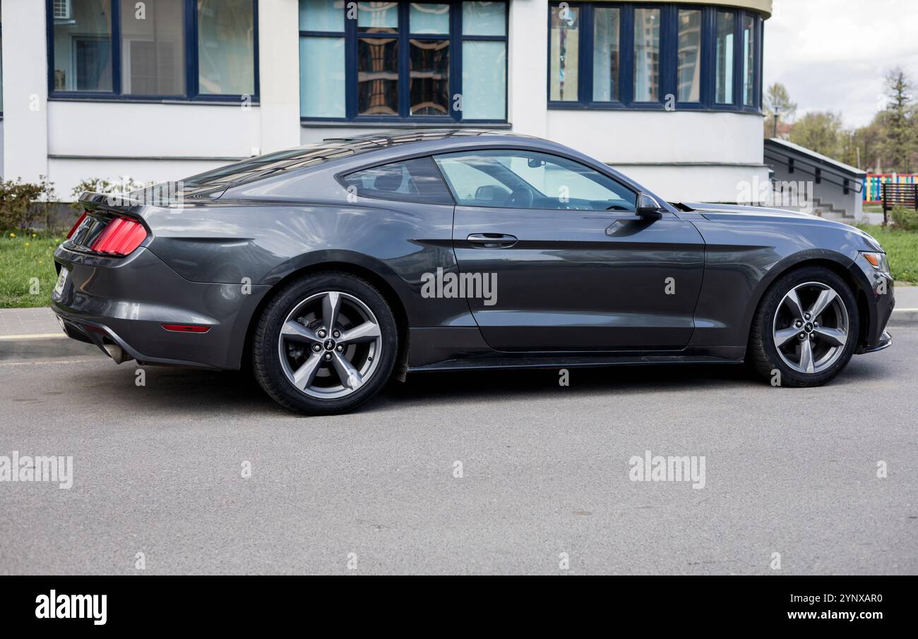 Minsk, Belarus, November 27, 2024 - Side view of fast sports car Ford Mustang parked in city streets Stock Photo