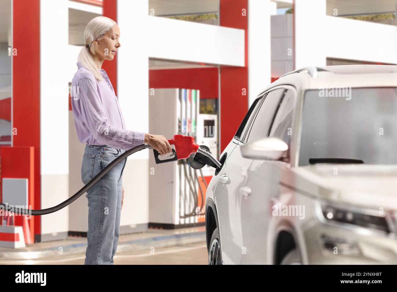 Woman filling a car with gasoline at a petrol station Stock Photo - Alamy