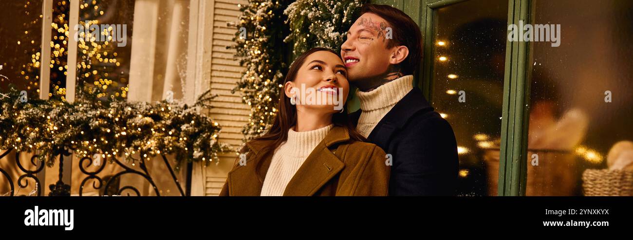 A young couple enjoys a romantic winter evening outdoors, surrounded by festive lights. Stock Photo