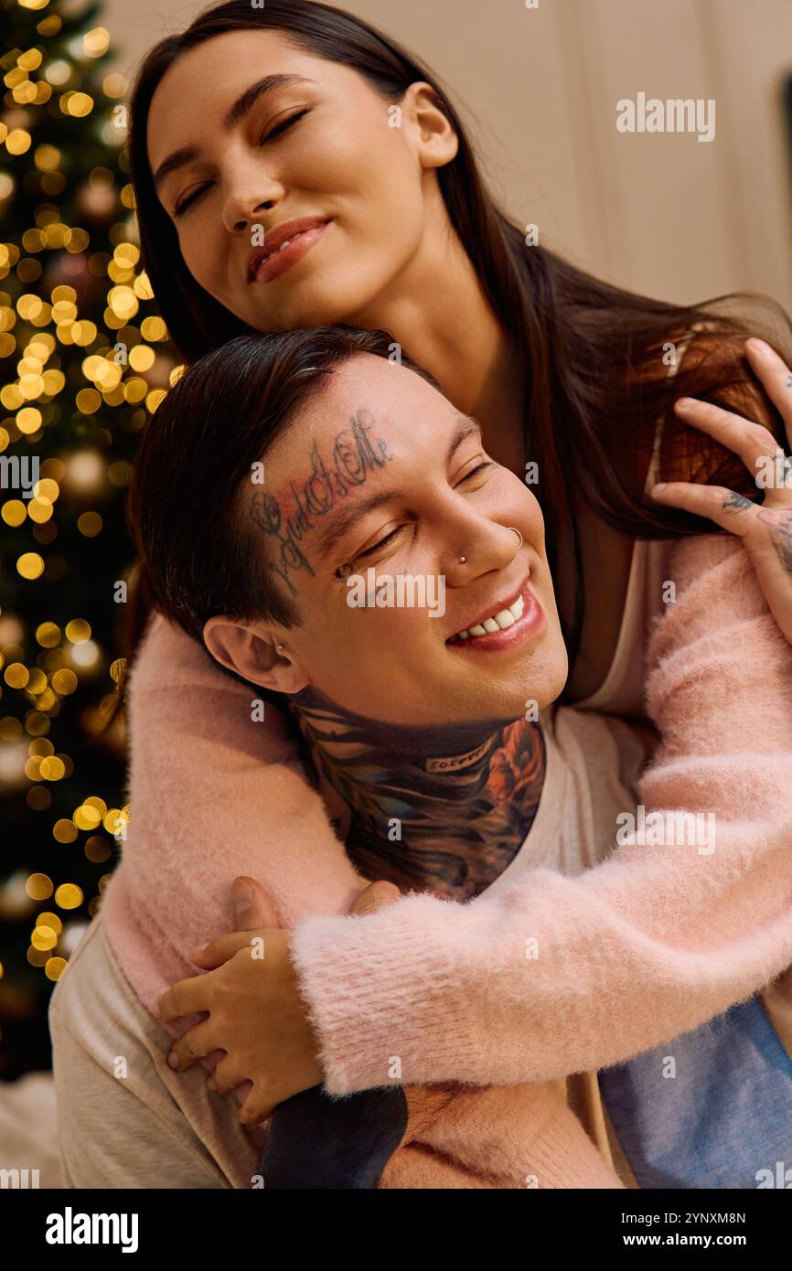 Loving couple shares warmth and happiness while enjoying festive moments by the decorated tree Stock Photo