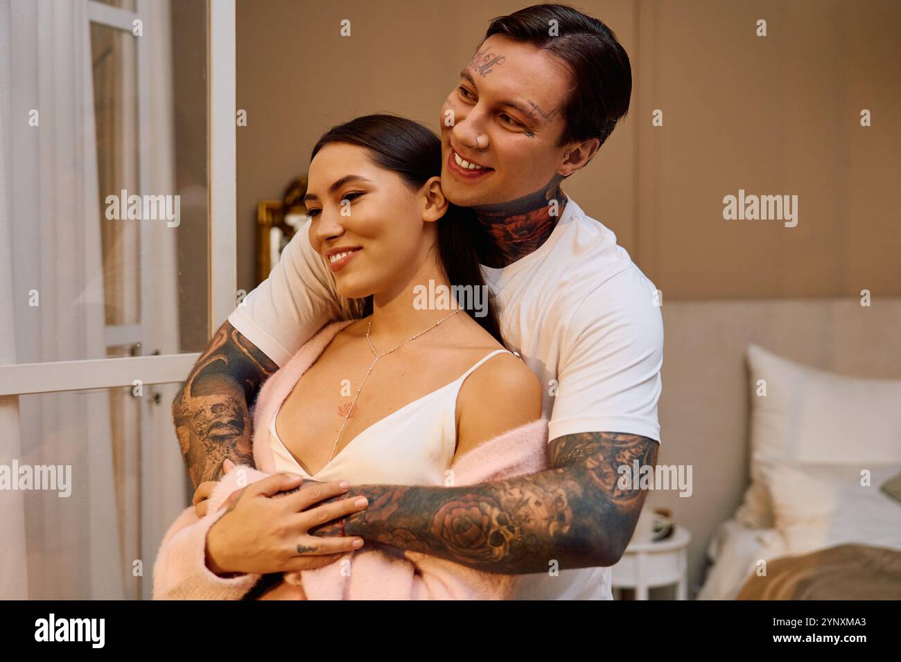 Young couple shares a joyful moment while hugging inside a warm and inviting room. Stock Photo