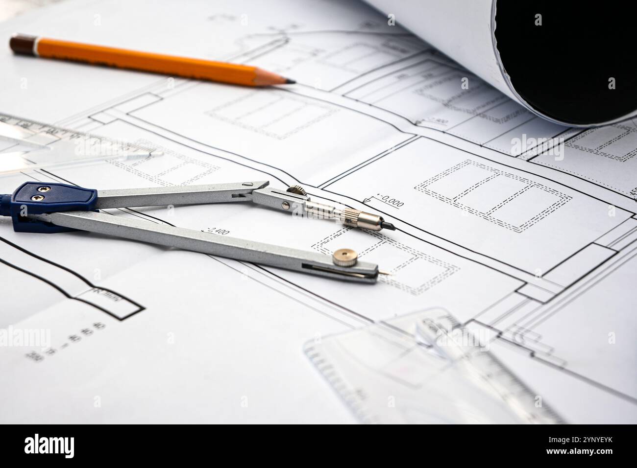 Architectural project with compass, pencil and rolled blueprints lying ...