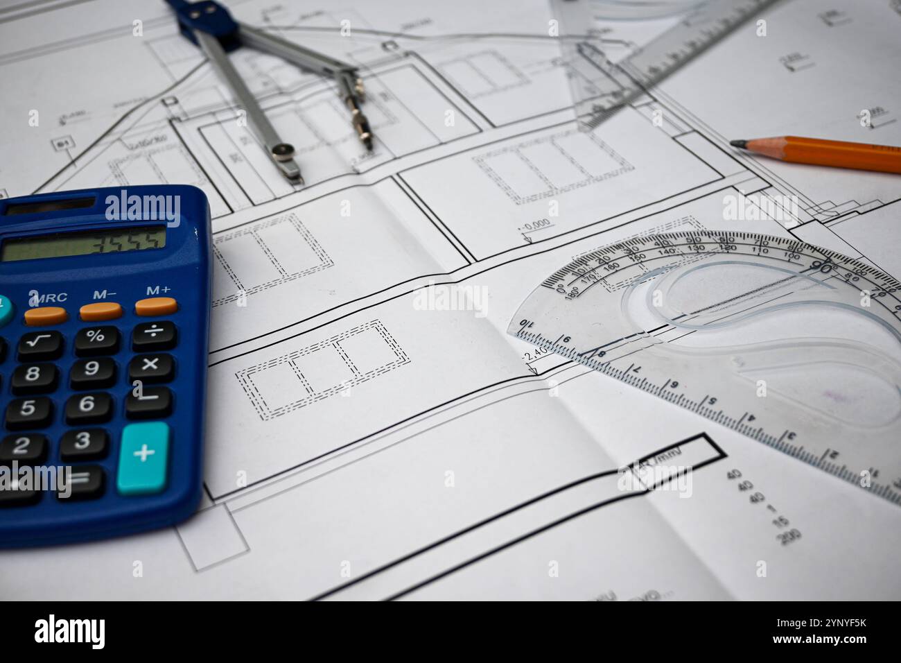 Workplace of architect designing blueprint of building using calculator ...