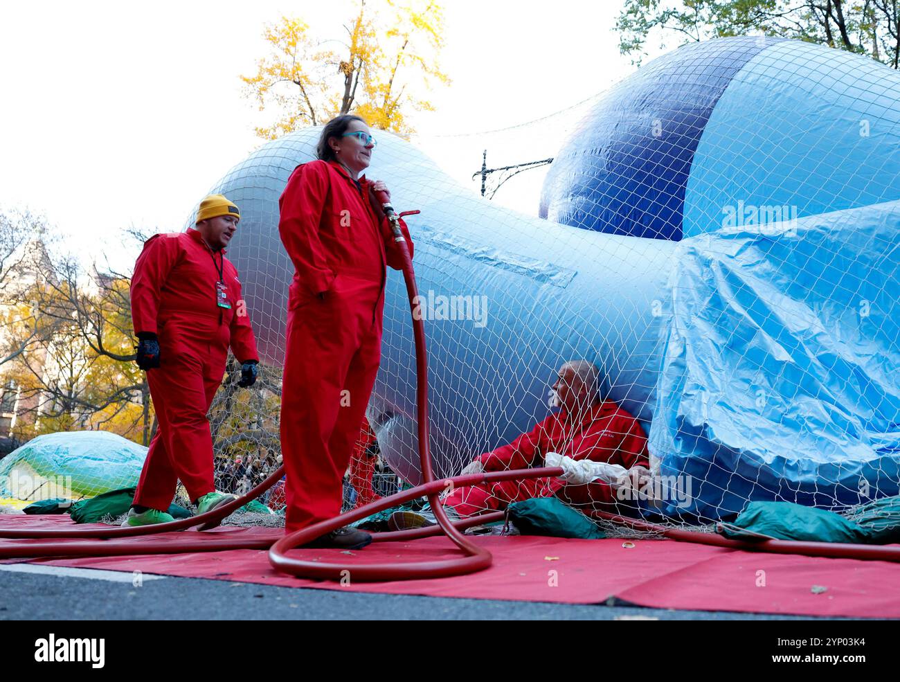 New York, United States. 27th Nov, 2024. A worker inflates the Bluey ...