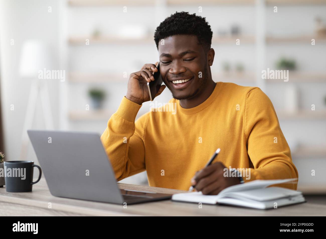 Happy black man freelancer working from home Stock Photo