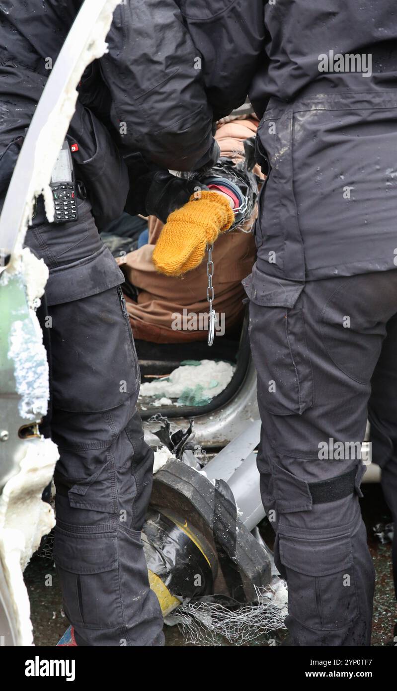 Specialist police officers snip an activist from a lock-on in one of the cars during the rally. Protesters block both road accesses to the UAV Engines factory site for the second time in three days. The company owned by Israeli weapons manufacturer Elbit Systems makes engines for the Hermes series of drones used by the Israeli military in Gaza and elsewhere. Palestine Action are determined to relentlessly target Elbit and their partner companies by regular protest and direct action and make business for them in the UK impossible. The UK government recently announced the cancellation of a £2.1b Stock Photo