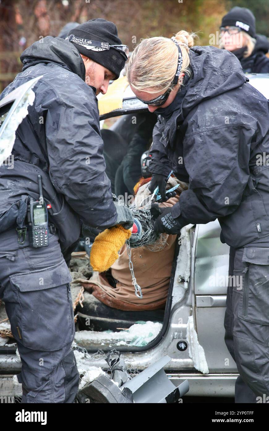 Specialist police officers snip an activist from a lock-on in one of the cars during the rally. Protesters block both road accesses to the UAV Engines factory site for the second time in three days. The company owned by Israeli weapons manufacturer Elbit Systems makes engines for the Hermes series of drones used by the Israeli military in Gaza and elsewhere. Palestine Action are determined to relentlessly target Elbit and their partner companies by regular protest and direct action and make business for them in the UK impossible. The UK government recently announced the cancellation of a £2.1b Stock Photo