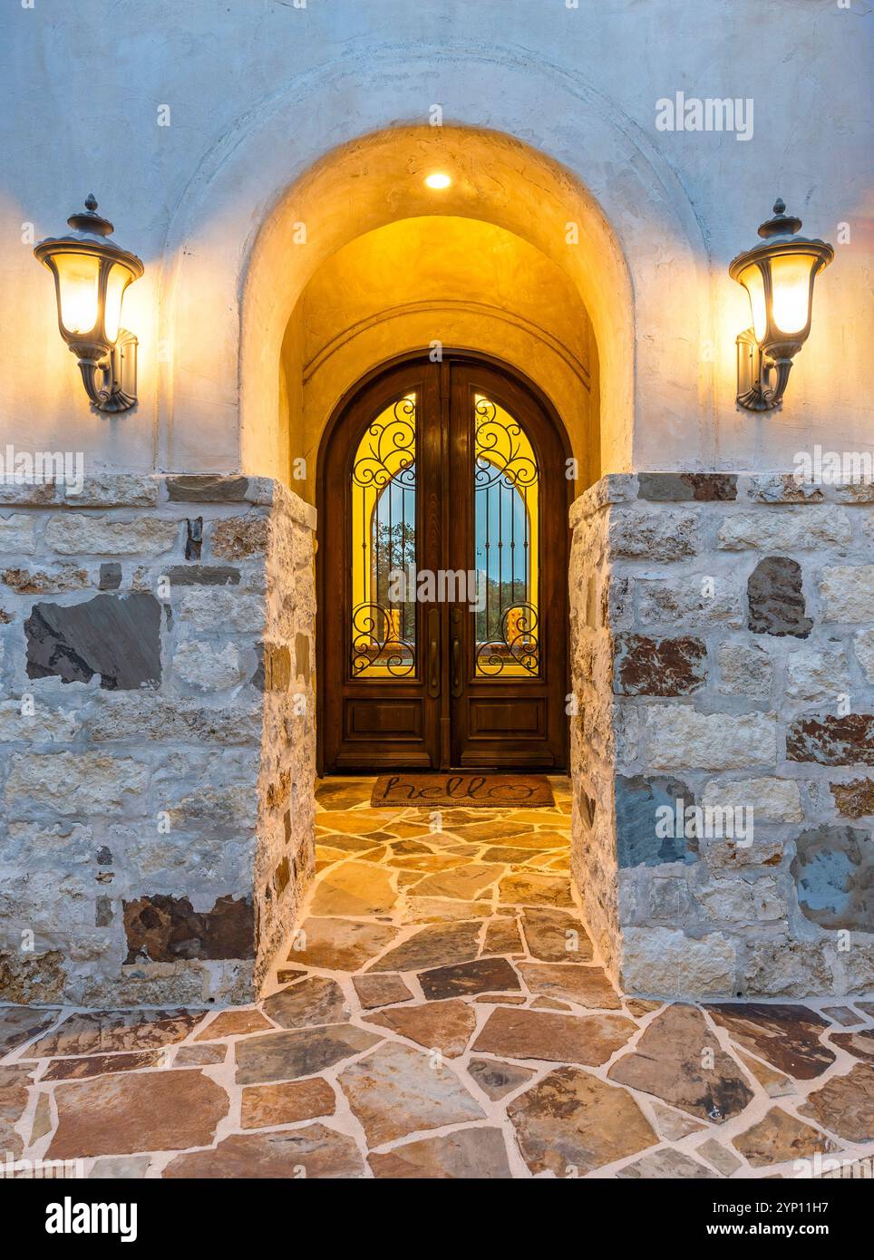 Beautiful entrance of a custom home with stone exterior and glowing ...