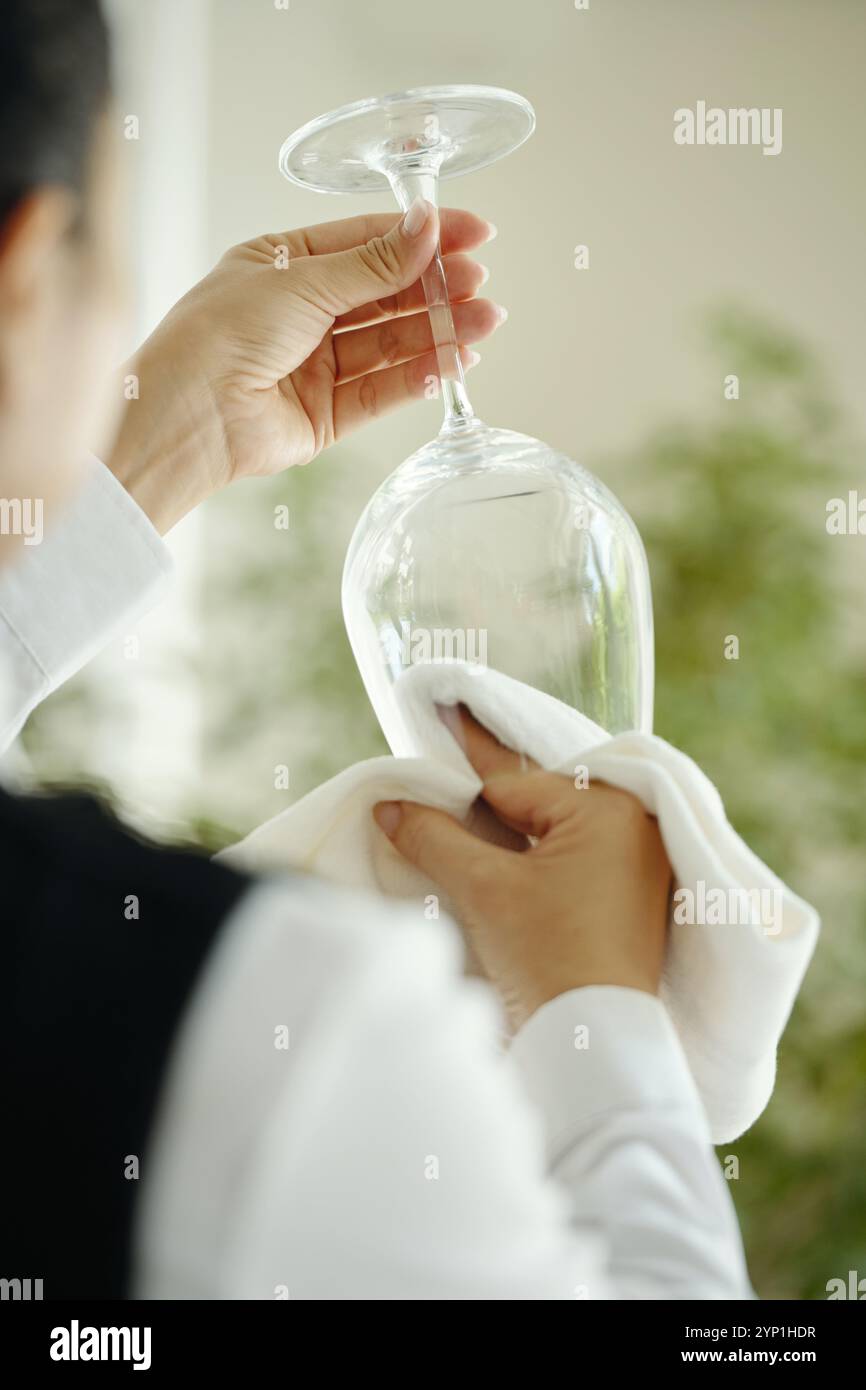 Polishing Stemware in Bright Kitchen Setting Stock Photo